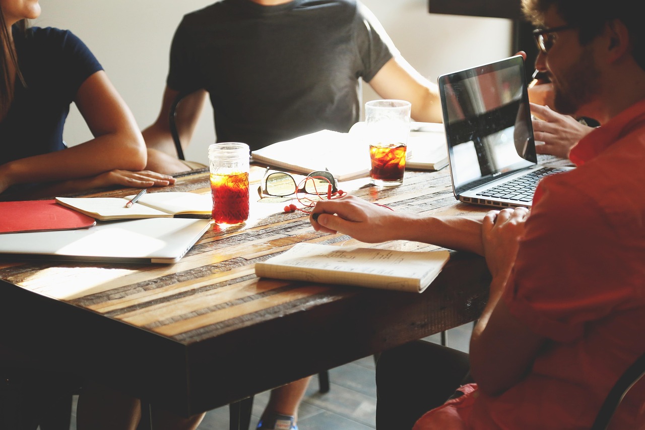 Group of homeowners gathered around a table in a meeting, discussing community issues and demonstrating active participation in an HOA meeting.