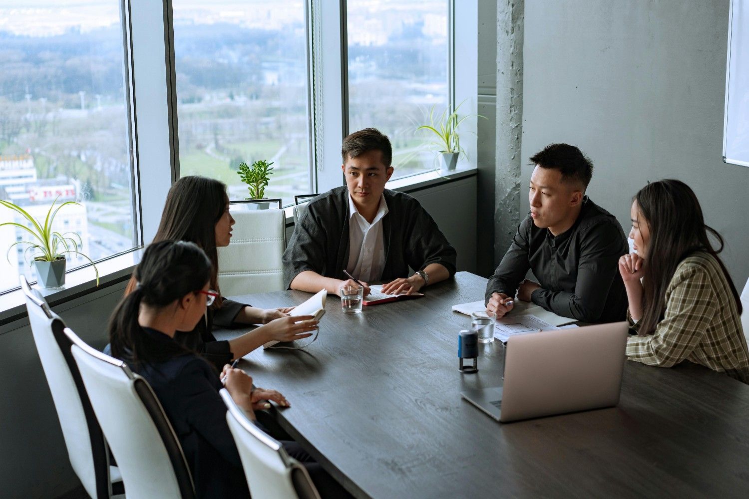 A professional HOA management board sits around a modern high-rise conference table, collaborating efficiently on community planning and operations.